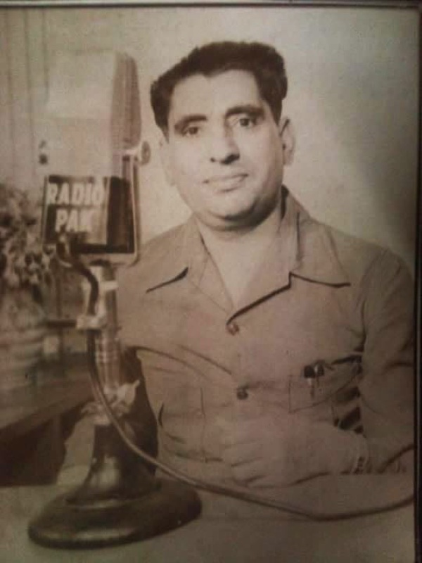 A younger Hazrat Zia Jaffry (R.A.) seated at a Radio Pakistan microphone