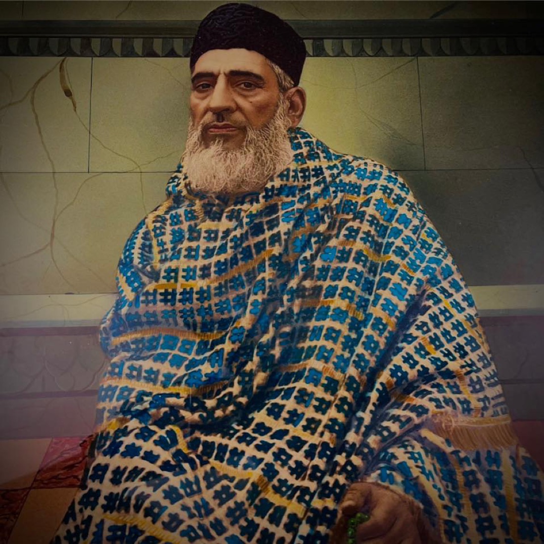 Hazrat Syed Inayat Ali Shah Zia Jaffry (R.A.) seated, wearing a patterned shawl